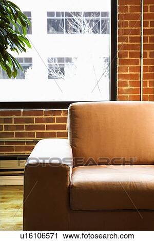 Cushy chair in loft apartment with houseplant in front of window View Large Photo Image Stock Image - Cushy chair in loft apartment with houseplant in front of window. Fotosearch