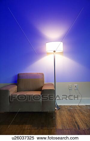 Stock Photography - Modern chair and floor lamp with blue cast from projection. Fotosearch