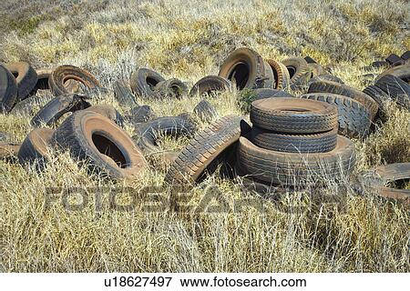 Stock Photo - Old dirty abandoned tires in field. Fotosearch