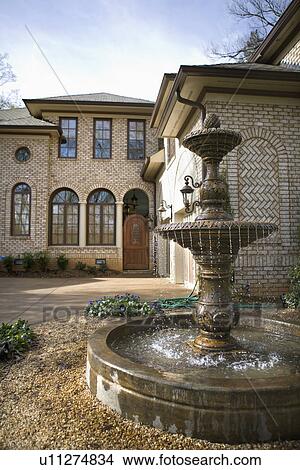 Picture - Outdoor front view of affluent home with fountain.. Fotosearch