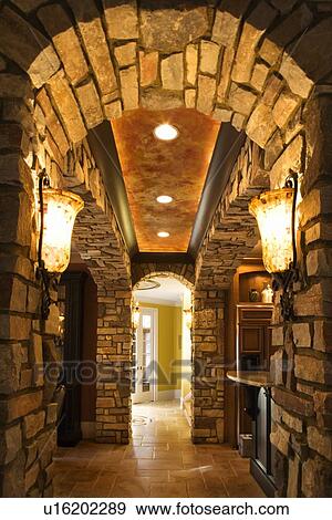 View of foyer through stone archway in affluent home View Large Photo Image Stock Photo - View of foyer through stone archway in affluent home. Fotosearch