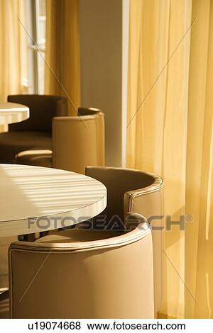 Warm toned table and chairs by window with drapes View Large Photo Image Stock Photo - Warm toned table and chairs by window with drapes. Fotosearch
