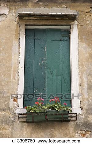 Stock Image - Window with closed shutters and flowerbox in Venice, Italy. Fotosearch