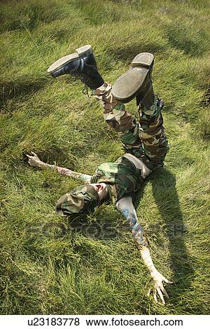 Attractive tattooed Caucasian woman in camouflage lying on grass with her legs up in the air View Large Photo Image Stock Photo - Attractive tattooed Caucasian woman in camouflage lying on grass with her legs up in the air . Fotosearch