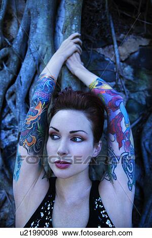 Stock Photo - Blue-toned portrait of tattooed woman with Banyan tree . Fotosearch