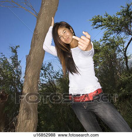 Young adult Asian female with one hand on tree and other hand giving the viewer the middle finger. View Large Photo Image Stock Photo - Young adult Asian female with one hand on tree and other hand giving the viewer the middle finger.. Fotosearch