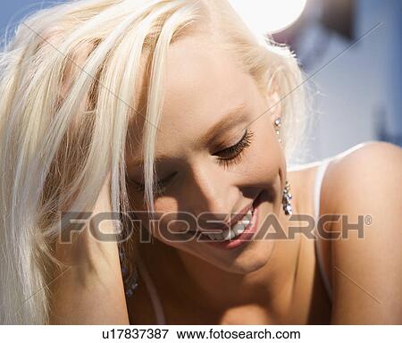 Portrait of attractive blonde Caucasian young adult woman smiling and looking down. View Large Photo Image Stock Photo - Portrait of attractive blonde Caucasian young adult woman smiling and looking down.. Fotosearch