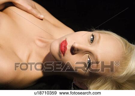 Portrait of attractive blonde Caucasian young adult woman lying down making sultry exprression at viewer. View Large Photo Image Stock Photo - Portrait of attractive blonde Caucasian young adult woman lying down making sultry exprression at viewer.. Fotosearch
