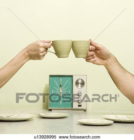 Caucasian male and female hands toasting with coffee cups across retro kitchen table setting. View Large Photo Image Stock Photography - Caucasian male and female hands toasting with coffee cups across retro kitchen table setting.. Fotosearch