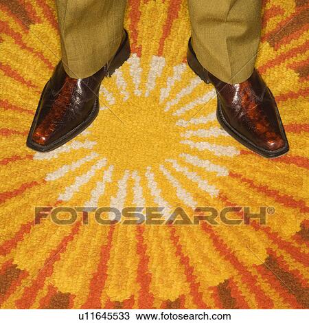Close-up of Caucasian mid-adult male feet in vintage boots against sunburst rug. View Large Photo Image Stock Image - Close-up of Caucasian mid-adult male feet in vintage boots against sunburst rug.. Fotosearch