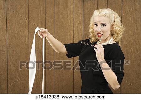 Stock Photo - Female in vintage outfit holding a printout and eye glasses.. Fotosearch