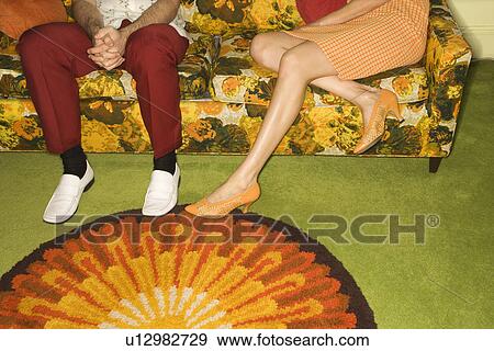 Female legs playing footsie with male legs by colorful retro sofa. View Large Photo Image Stock Photo - Female legs playing footsie with male legs by colorful retro sofa.. Fotosearch