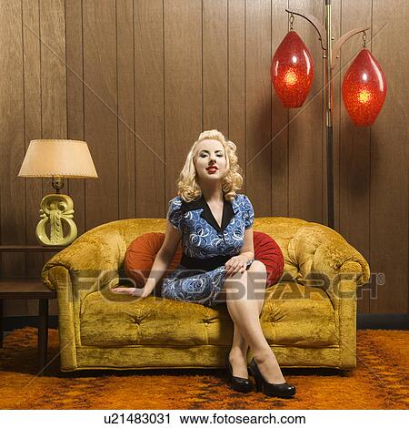 Stock Image - Woman sitting in retro decorated room. Fotosearch