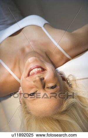 Portrait of attractive blonde Caucasian young adult woman lying upside down smiling and looking at viewer. View Large Photo Image Stock Photography - Portrait of attractive blonde Caucasian young adult woman lying upside down smiling and looking at viewer.. Fotosearch