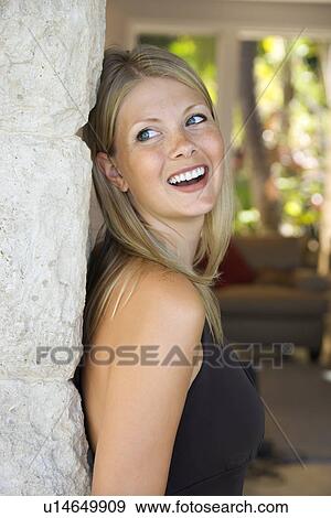 Stock Photo - Woman looking over shoulder smiling. Fotosearch