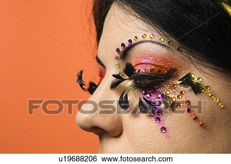 Close-up of woman in unique makeup against orange background View Large Photo Image Stock Photograph - Close-up of woman in unique makeup against orange background. Fotosearch