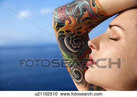Close up portrait of tattooed woman with Pacific Ocean in background View Large Photo Image Stock Image - Close up portrait of tattooed woman with Pacific Ocean in background . Fotosearch