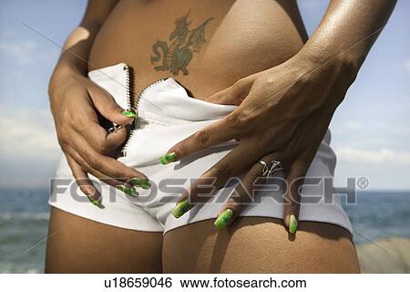 Multi ethnic young adult woman on beach unzipping shorts. View Large Photo Image Stock Photograph - Multi ethnic young adult woman on beach unzipping shorts.. Fotosearch