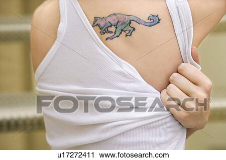 Stock Image - Portrait of young woman with tattoo on shoulder. Fotosearch