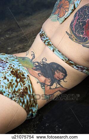 Sexy tattooed Caucasian woman in bikini lying in tidal pool View Large Photo Image Picture - Sexy tattooed Caucasian woman in bikini lying in tidal pool . Fotosearch
