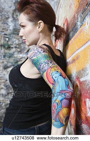 Sexy tattooed woman leaning on wall covered in graffiti View Large Photo Image Stock Photo - Sexy tattooed woman leaning on wall covered in graffiti. Fotosearch