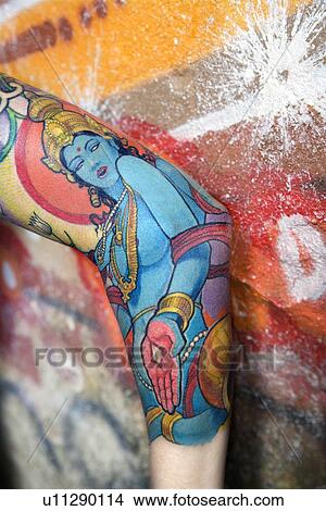 Tattooed woman's arm next to concrete wall covered with graffiti View Large Photo Image Picture - Tattooed woman's arm next to concrete wall covered with graffiti. Fotosearch