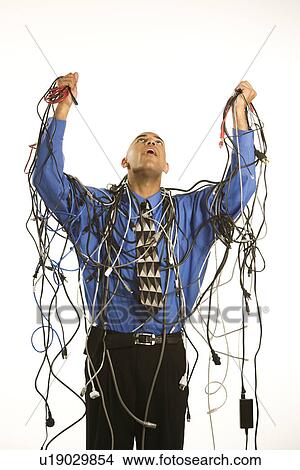 Picture - Businessman holding tangled cords. Fotosearch