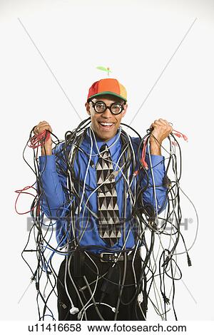 Stock Photo - Businessman wrapped in computer cables wearing nerd hat and glasses. Fotosearch