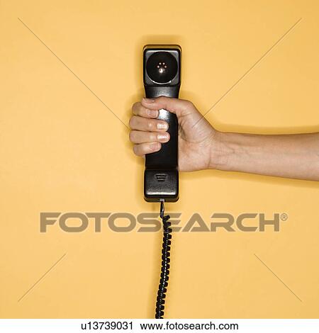 Close up of woman holding telephone receiver on yellow background View Large Photo Image Stock Image - Close up of woman holding telephone receiver on yellow background. Fotosearch