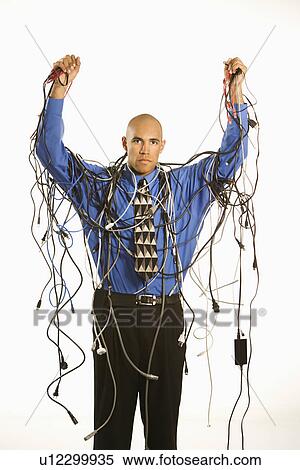 Stock Photography - Front view of upset businessman wrapped in cords. Fotosearch