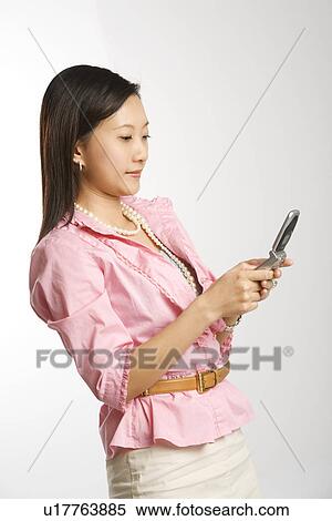 Portrait of Asian Chinese mid-adult female text messaging on cell phone. View Large Photo Image Stock Photography - Portrait of Asian Chinese mid-adult female text messaging on cell phone.. Fotosearch