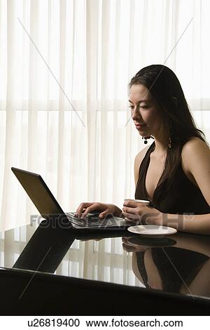Woman at a desk with a laptop View Large Photo Image Stock Image - Woman at a desk with a laptop. Fotosearch