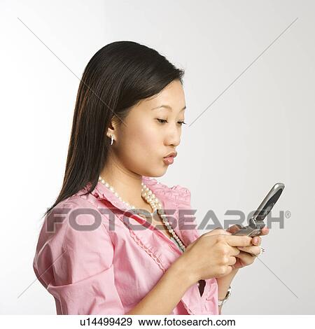 Woman in business apparel texting on a cellphone View Large Photo Image Stock Photo - Woman in business apparel texting on a cellphone. Fotosearch