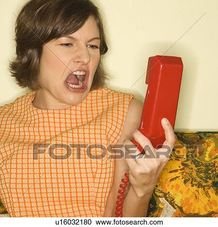Stock Image - Woman screaming into a phone. Fotosearch