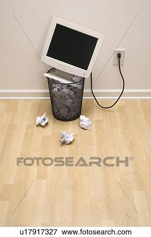Stock Photo - Computer monitor in trash can surrounded by crumpled up paper. Fotosearch