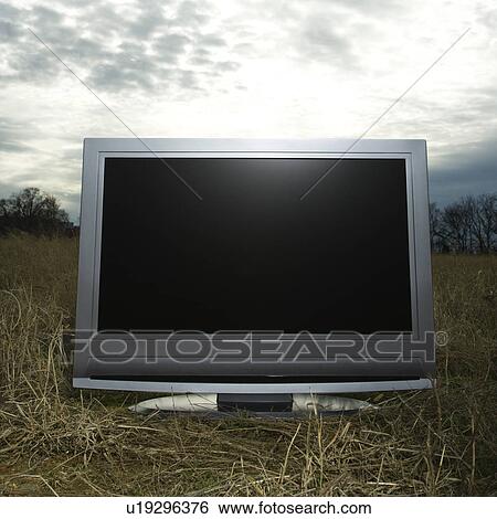 Stock Photograph - Flat panel television set in grassy field. Fotosearch
