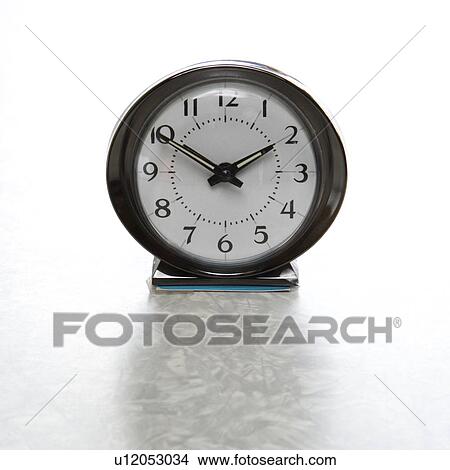 Picture - Still life of round vintage alarm clock on table. Fotosearch