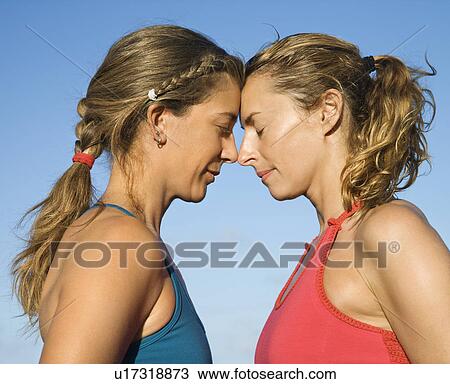 Stock Image - Caucasian mid-adult women with heads together.. Fotosearch