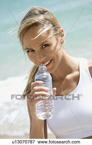 Caucasian young adult woman drinking water on beach. View Large Photo Image Stock Photo - Caucasian young adult woman drinking water on beach.. Fotosearch