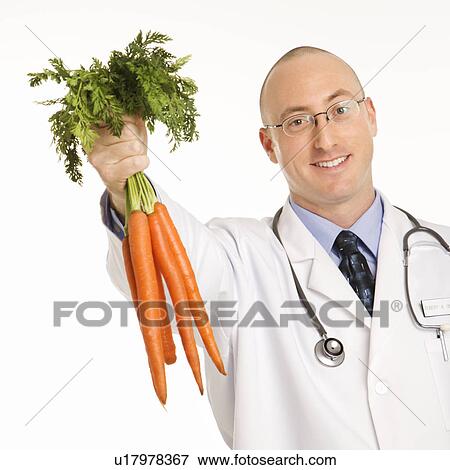Male physician holding bunch of carrots View Large Photo Image Stock Photo - Male physician holding bunch of carrots. Fotosearch