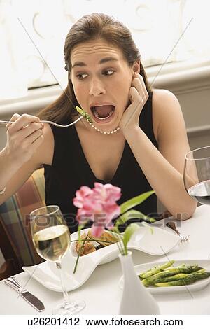 Woman making exaggerated expression while eating with fork to mouth View Large Photo Image Stock Image - Woman making exaggerated expression while eating with fork to mouth. Fotosearch