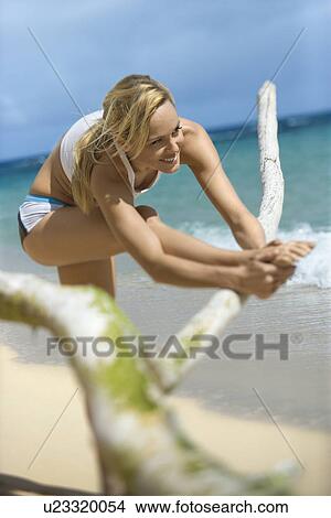 Picture - Woman stretching on beach. Fotosearch