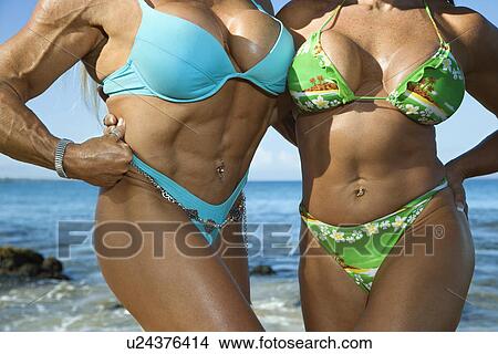 Picture - Women bodybuilders in bikinis on beach. Fotosearch