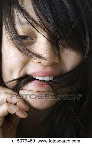 Close up portrait of pretty young Asian woman biting her hair. View Large Photo Image Stock Photo - Close up portrait of pretty young Asian woman biting her hair.. Fotosearch