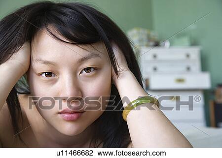 Portrait of pretty young woman laying in bed with hands in hair making eye contact View Large Photo Image Stock Image - Portrait of pretty young woman laying in bed with hands in hair making eye contact. Fotosearch