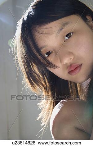 Stock Photograph - Portrait of pretty young woman making eye contact. Fotosearch