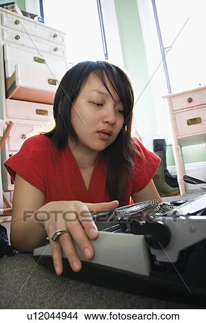 Woman lying on floor in red robe typing on typewriter View Large Photo Image Picture - Woman lying on floor in red robe typing on typewriter. Fotosearch