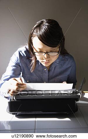 Woman sitting in chair typing on typewriter in kitchen View Large Photo Image Stock Image - Woman sitting in chair typing on typewriter in kitchen. Fotosearch