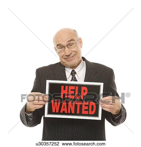 Stock Image - Businessman holding help wanted sign. Fotosearch