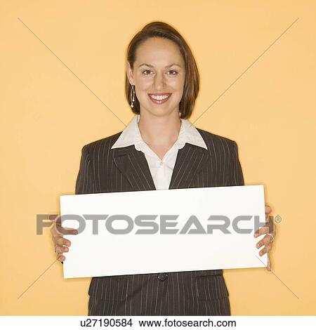 Businesswoman smiling holding blank sign View Large Photo Image Picture - Businesswoman smiling holding blank sign. Fotosearch